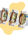 Three hot dogs with various toppings on a yellow and white checkered background