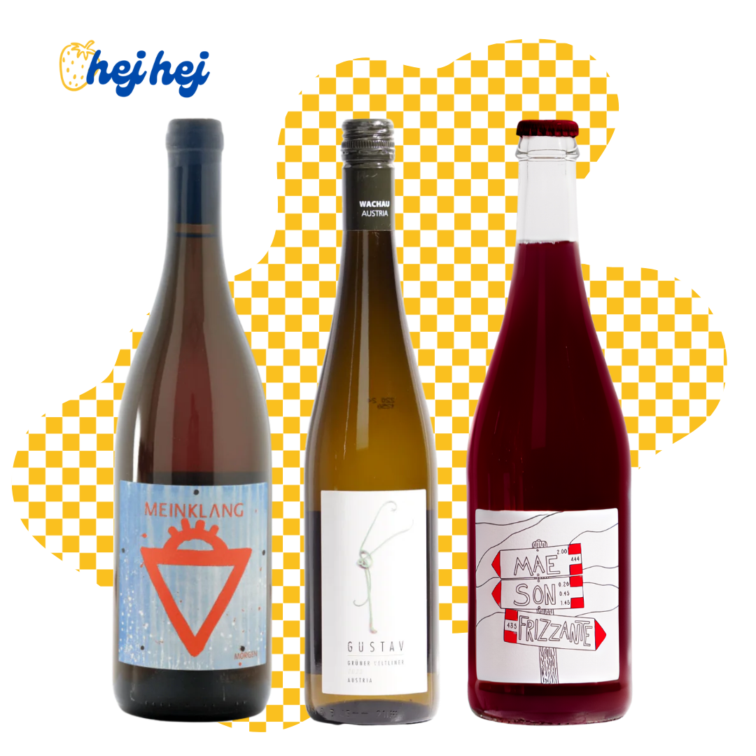 Three wine bottles with labels on a yellow and white checkered background, featuring the brand 'hej hej'.