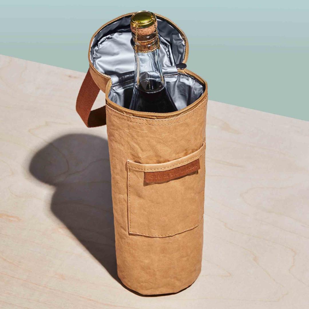 Brown insulated wine bag with a bottle of wine on a light marble surface.