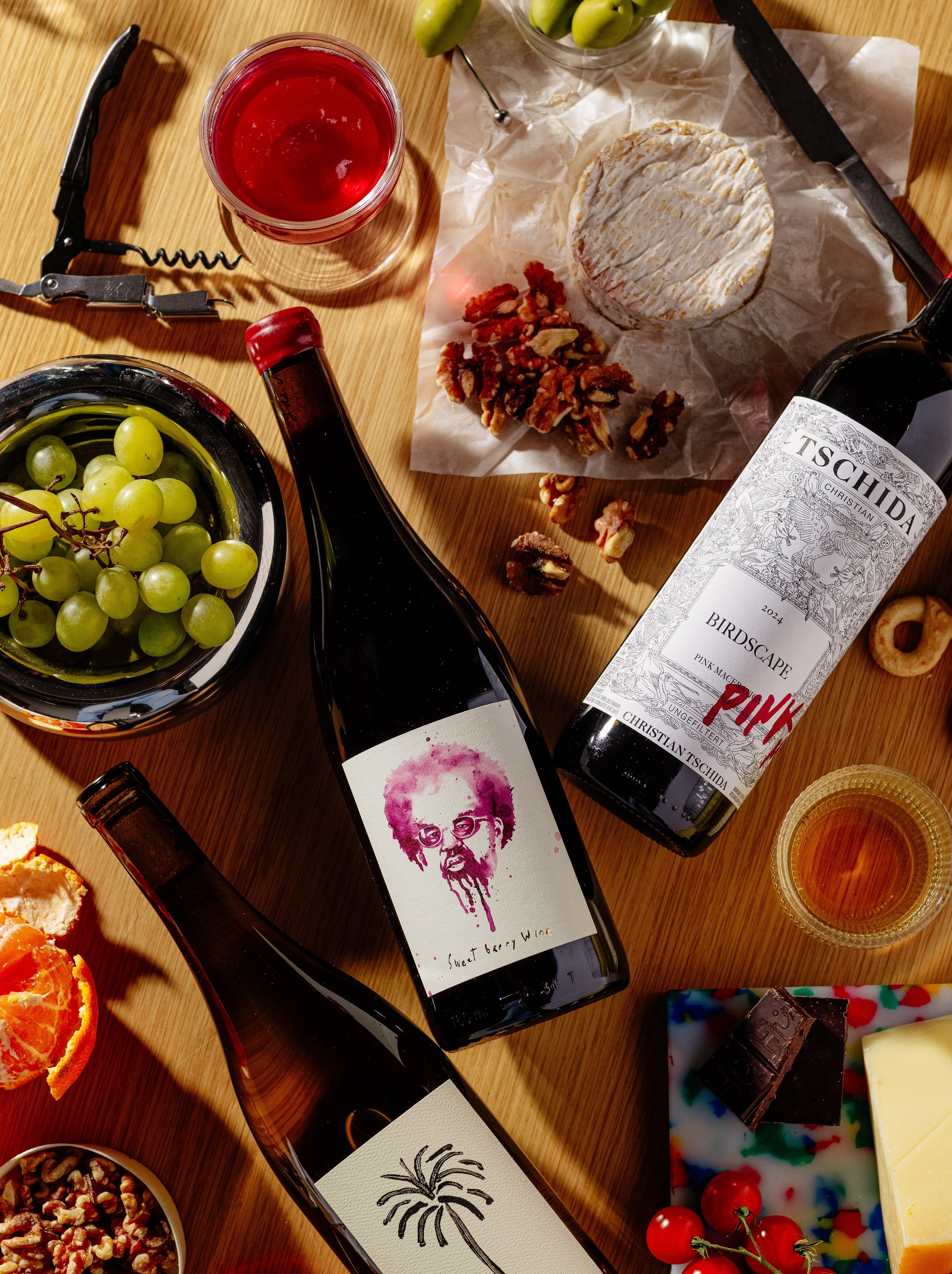 Las Jaras Chenin Blanc and Sweet Berry natural wines from California with fresh fruit flavors served with cheese, grapes, and nuts on wooden table for Mysa Natural Wine