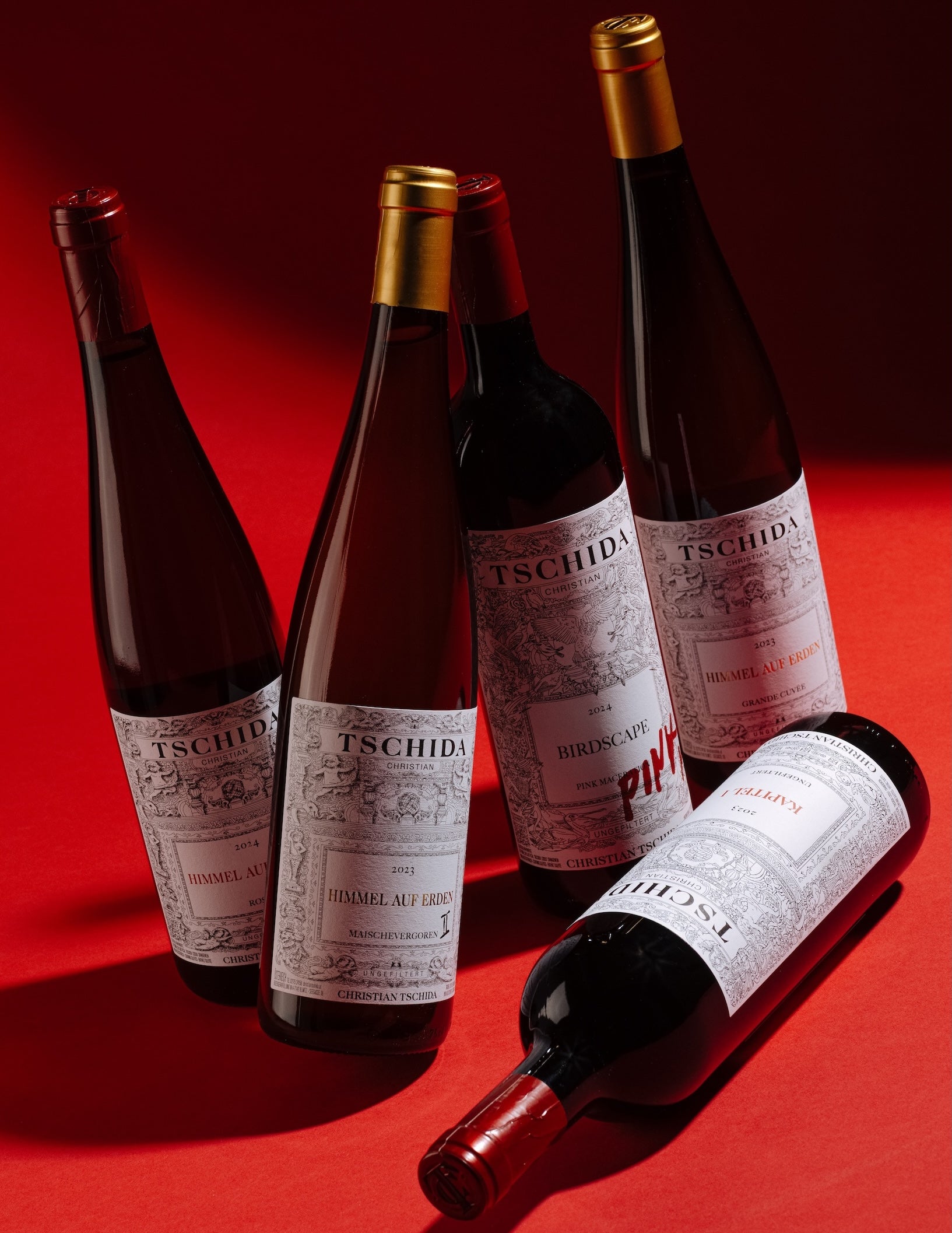 Christian Tschida natural wine bottles collection including Himmel auf Erden and Birdscape from Burgenland Austria on red background for Mysa Natural Wine